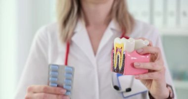 Diş ve haplar dişçinin elinde. Diş etleri ve diş köklerinin iltihaplanması için antibiyotikler.