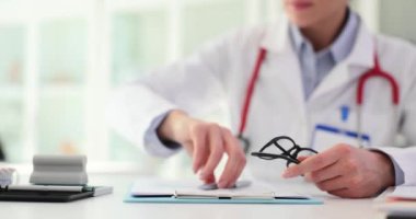 Doktor iş yerinde yakın çekim yazıyor. Hasta tıbbi verileri ve reçetesi