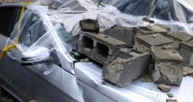 Yıkıcı deprem ve araba enkaz altında kaldı. Arabanın kaputunda beton bloklar