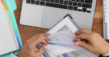 Belgeleri doldurmak ve finansal tabloları analiz etmek. İşadamı ofiste evrakları karıştırıyor.