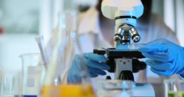 Tıbbi kimyager laboratuardaki petri kabında kimyasal bir maddeyi analiz ediyor. Laboratuvarda mikroskopla çalışan bilim adamı biyolog laboratuvar asistanı.