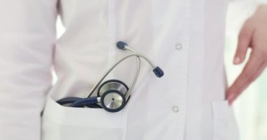 Cebinde steteskop olan beyaz önlüklü bir doktor. Tıbbi bakım sağlanıyor.