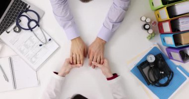 Kadın dermatolog, erkek hastanın ellerindeki ve saçlarındaki deriyi kontrol ediyor. El soyma problemi