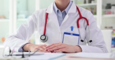 Steteskoplu kendine güvenen kadın doktor ziyaretçiyi karşılamaya hazır. Kadın, profesyonellik ve uzmanlık aşılayan güven duygusu yayar.