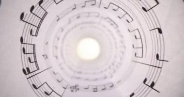 Müzik sayfaları sayfasında ışığa karşı yuvarlanmış notalar var. Müzisyen için seslerin grafiksel sembolleri. Müzik bileşimi