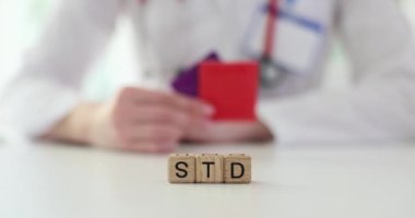 Doktor cinsel yolla bulaşan hastalıkları önlemek için prezervatif gösteriyor. Kadın hastaları cinsel sağlığa öncelik vermeye ve riskleri azaltmak için proaktif adımlar atmaya teşvik ediyor