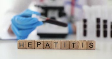 Doktor, laboratuvarda hepatit kelimesinin üzerinde kan testi tüpü olduğunu gösteriyor. Tehlikeli hastalık farkındalığı kavramı. Karaciğer iltihabı