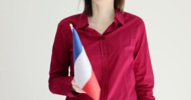 İşçi zarif bir şekilde gri arka planda Fransa bayrağı sallıyor. Vatansever çalışan ülke başarıları için gurur ve takdir gösteriyor