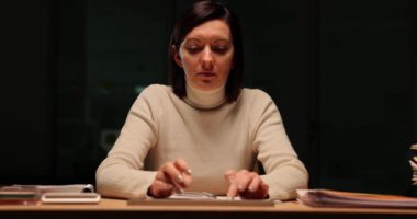Şirket çalışanı tipleri işyerindeki klavyede yavaş çekimde rapor verir. Çok çalışan kadın çalışanlar gece geç saatlerde belgeleri hazırlıyorlar.