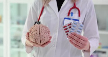 Kadın doktor klinikte ilaç ve insan beyni mankeni yapıyor. Nöropatolog, hastanede hastalık önleyiciler için eczane gösterdi