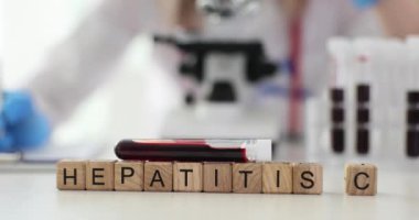 Tahta küplerde kan örneği şişesinin yanında Hepatit C görülüyor. Viral enfeksiyonun yol açtığı karaciğer iltihabına karşı devam eden mücadele