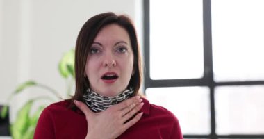 Kadın boynuna dolanmış ağır metal bir zincir taşıyor. Kadın stresle ve endişeyle mücadele eden sıkıntılı koşulların arasında nefes almaya çalışıyor.