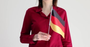 Gri arka planda Alman bayrağıyla rafine hareket eden kadın. Kadın, pozitif görünüm ve dayanıklılık ruhuna sahip ulusları özetliyor.