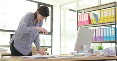 Genç bayan ofis çalışanı belgelerin içeriğini fotoğraflıyor. Profesyonel çalışan, net görüntüleri yakalamak için çağdaş akıllı telefonu kullanır