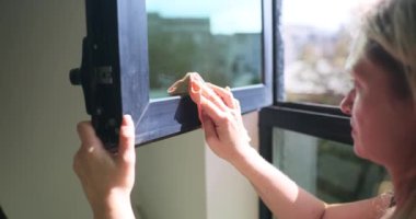 Ev hanımı evdeki her pencereyi titizlikle temizliyor. Genç kadın çabaları pencerelerin pırıl pırıl ve pırıl yüzeyi ile sonuçlandı