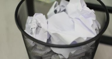 Çalar saat ofisteki kağıtlarla dolu çöp kutusuna düşer. Zaman akışını ve çalışma ortamındaki aralıksız çalışma hızını anımsatıyor.