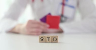 Tahta küplerden gelen kelime hastanedeki doktorlara karşı. Kadın terapist, riskleri azaltmak için güvenliği hatırlatan prezervatifler gösteriyor
