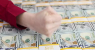 Genç bir kadın 100 dolarlık banknotları yumrukluyor. Kadın, bütçe planlamasının değerini yumruk yavaş çekimde vurguluyor