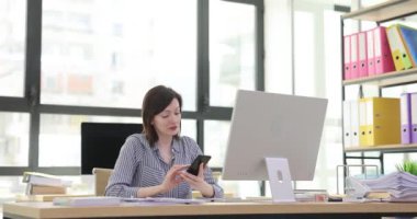 Kadın ofis çalışanı iş arkadaşına arama amacını açıklıyor. Profesyonel çalışan, telefon görüşmelerinin olumlu sonuçlarına seviniyor