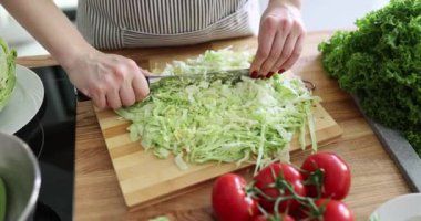 Aşçılığın mükemmelliğini gösteren lahana kesmek için şef bıçağı ustalıkla kullanır. Ev hanımı çok yönlü sebzeleri besleyici salataya eklemek için hazırlıyor.