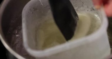 Aşçı tereyağını lokanta mutfağında bain-marie metoduyla eritiyor. Aşçı, daha fazla yemek yapmak için doğru malzemeyi hazırlar.