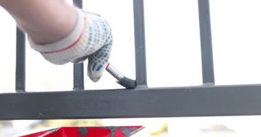 Bahşişler ve metal çit boyama teknikleri. Ressam metal balkon korkuluklarını griye boyuyor.