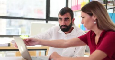 Erkek patron ve bayan yöneticiler dizüstü bilgisayarda iş birliği yaparlar. İş ortakları laptopta birlikte çalışıyorlar.