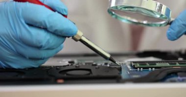 Yazılı devre kartını lehimleyen bir mühendis lehim makinesi ve büyüteç tutuyor. PCB montaj ve PCB yapım atölyesi konsepti