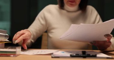 İş kadını gece geç saatlerde ofiste iş belgeleriyle çalışıyor. Ofisteki belgelerle fazla mesai yapıyorum.