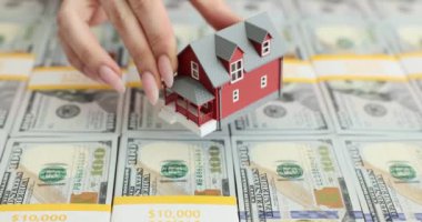 Bir ev modeli ve 100 dolarlık banknotlar. Kira, konut satın alma ve finansal yatırımlar
