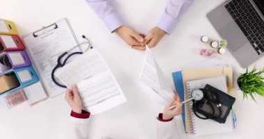 Klinikteki erkek hastaların tıbbi kardiyogram testlerini inceleyen doktorlar. Kalp ve damar hastalıklarının teşhisi
