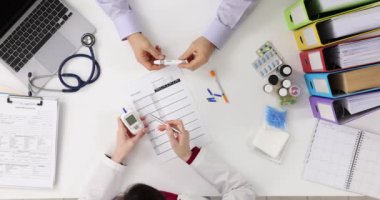 Doktor ve hasta kan şekeri sonuçlarını tartışıyor. Diyabet ve şeker kontrolü