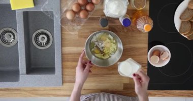 Mutfak manzarasında sütü ve yumurtayı kaseye karıştırın. Çırpılmış yumurta ve omlet pişiriyorum.
