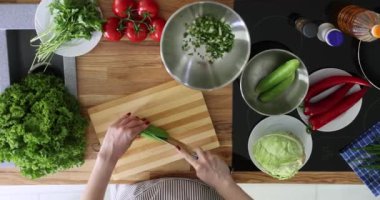 Salatalık ve sebze dilimleyen aşçı ya da ev hanımı. Lezzetli sebze salatası yapıyorum.