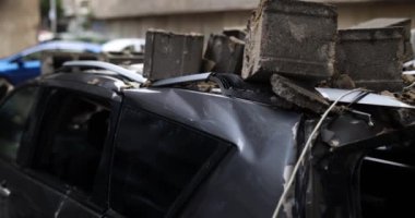 Mahvolmuş şehir bloğunun arabaları ve altyapısı. Otoparktaki arabanın kaputuna tuğla blokları ve depremin sonuçları