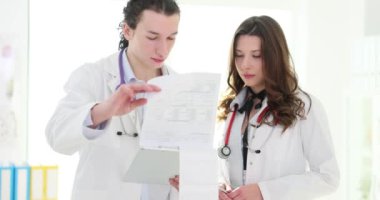 İki doktor hastane kayıtlarını inceliyor. Tıbbi meslektaşlarım hasta teşhisini tartışıyor
