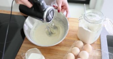 Şef önlük takıyor, elektrikli mikser kullanarak hamur yoğuruyor. Krep hamuru hazırlanıyor.