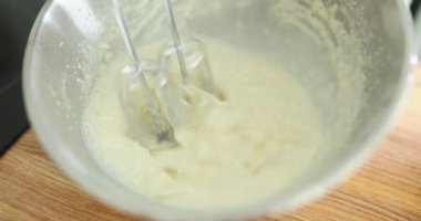 Cam kasede beyaz krema ve karıştırıcı. Krep hamuru hazırlanıyor.