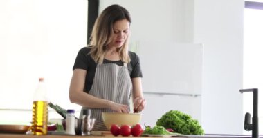 Kadın salata hazırlar ve modern mutfakta tadına bakar. Sebze salatası hazırlıyorum.