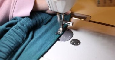 Dikiş makinesi kullanarak turkuaz kumaşa dikiş dikiyorum. Dikiş makinesinde dikiş servisi