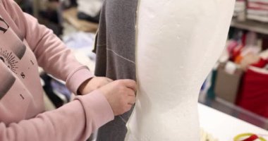 Moda tasarımcısı terzi atölyedeki beyaz manken üzerinde gri kumaş deniyor. Tasarımcı ve moda terziliği