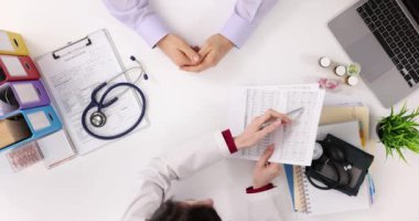 Doktor ve hasta kalp elektrokardiyogramını klinikte gözden geçiriyor. Belli bir zaman dilimindeki kalp kası çalışmaları