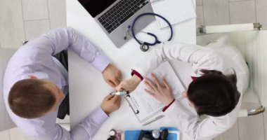 Kadın doktor sinir sistemini ve hastanın gözlerini inceliyor. Nörolog hastayı muayene ediyor.