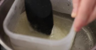 Mutfaktaki bir su banyosunda yemek pişirmek için içinde su ve cam kase olan tatlı bisküvi yapıyorum.