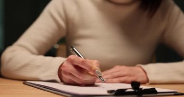 Muhasebeci gece ofiste kalemle kağıt üzerine yazı yazıyor. Geceleri fazla mesai.
