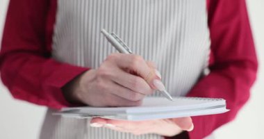 Garsonların not defteriyle yakınlaşması, kafeteryada veya restoranda müşteri siparişi alması. Önlüklü bir kafe çalışanı müşteriye hizmet ediyor ve hizmet kavramı yazıyor.