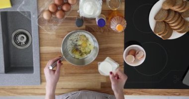 Mutfakta kahvaltı için yumurta ve süt hazırlıyorum. Süt ekliyorum ve yumurtayla karıştırıyorum.