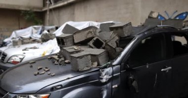 Deprem sırasında beton bloklar arabanın üzerine çöktü. Arabanın kaputunda beton bloklar