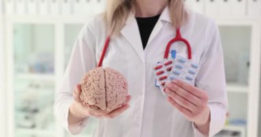 Doktor beyin modelini ve hapları klinikte tutuyor. Beyinde etkinliği kanıtlanmış nootropik maddeler
