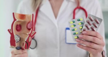 Doktor rektum modelini iki paket hapla tutuyor. Hemoroitlerin tedavisi